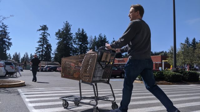 man leaving the grocery store