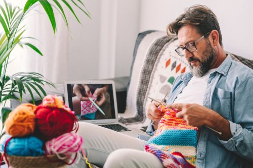 man knitting with online tutorial