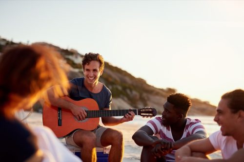 man playing guitar for friends
