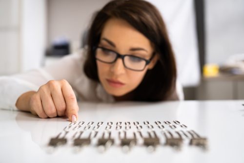 Young Woman Examining Paper Clips