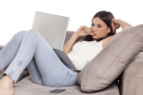 Young Woman Lounging on the Couch With Her Laptop