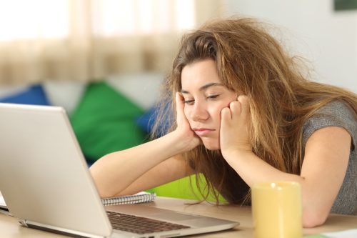 Tired Young Woman in Front of Laptop