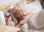 Satisfied middle-aged woman lying in bed enjoy early morning