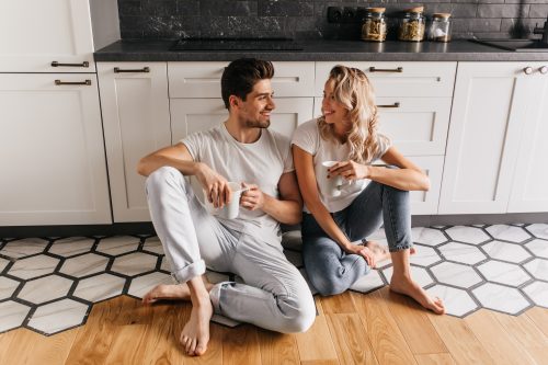 couple drinking their morning coffee on the floor of their kitchen