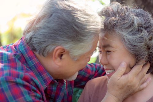 older couple embracing in park