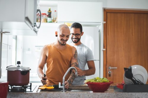 LGBT couple preparing food at home