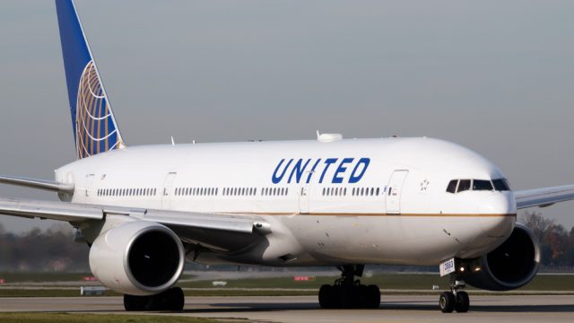 A United Airlines airplane taxiing on a runway at an airport