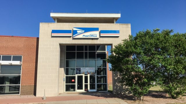 USPS store sunny summer clear blue sky. The United States Postal Service is an independent agency of US federal government providing postal service
