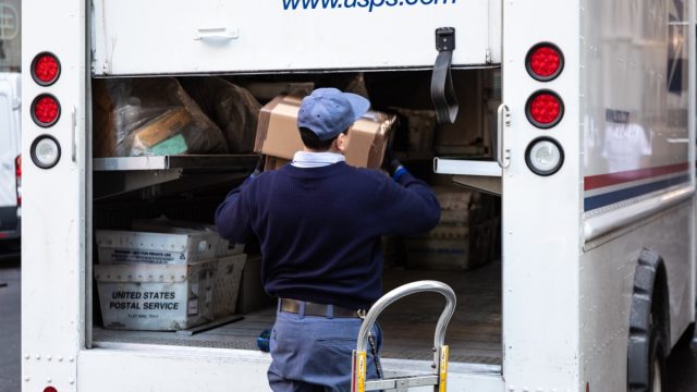New York City, USA - February 4, 2019: USPS Postal worker load truck parked on street of midtown of New York City