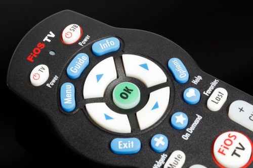 New York, New York, USA - July 8, 2011: The upper section of a Verizon FiOS remote control on a black reflective background. Focus is on the FiOS logo on the top of the remote.