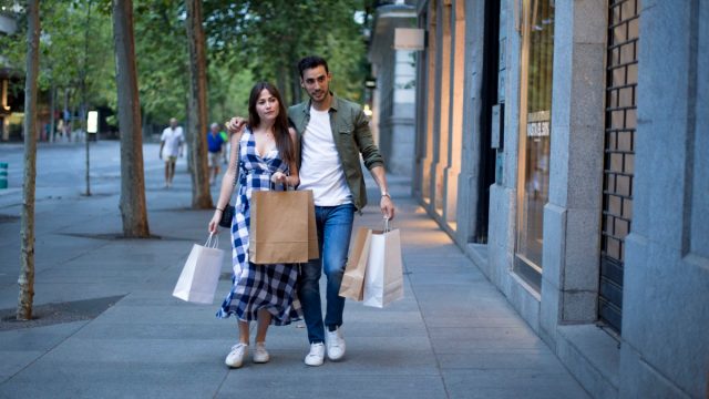 Couple embraced while shopping in a commercial street in the evening