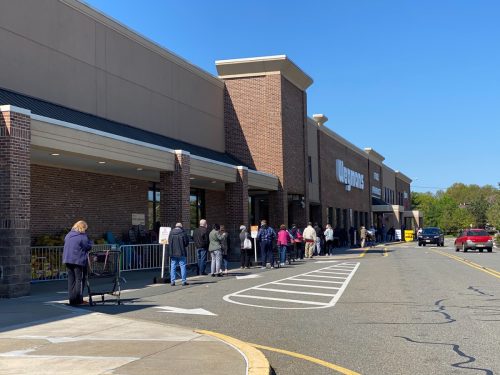 Shoppers wait outside in a line to get into the Wegmans supermarket, part of the Covid-19 social distancing guidelines during the pandemic