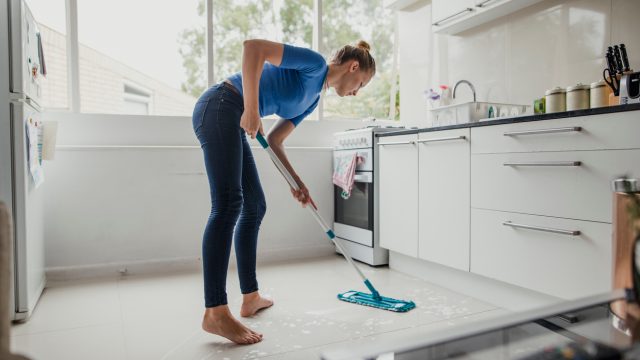 A woman mopping a kitchen floor