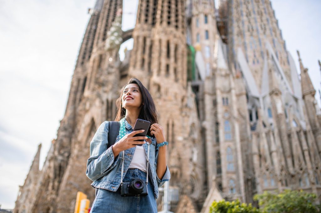 A woman standing in front of the Sagrada Familia cathedral