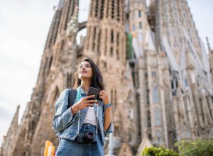 A woman standing in front of the Sagrada Familia cathedral