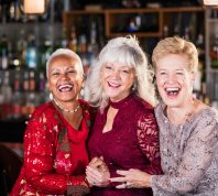 Three older women in cocktail dresses