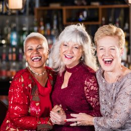 Three older women in cocktail dresses