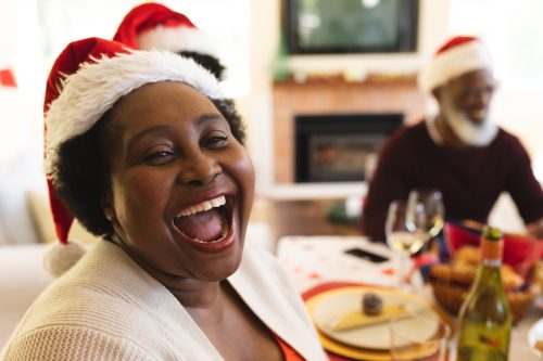family laughing at Christmas jokes at the dinner table