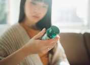 woman looking at supplement bottle