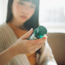 woman looking at supplement bottle