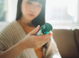 woman looking at supplement bottle