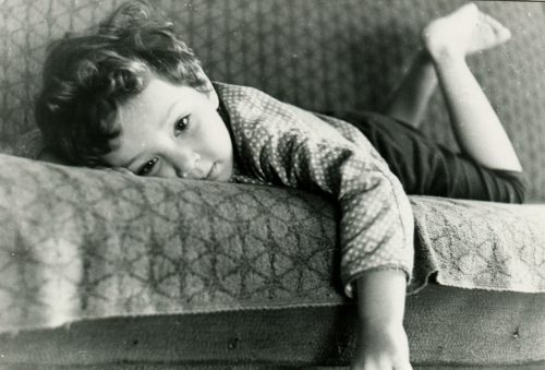 vintage photo of a little boy laying on a couch