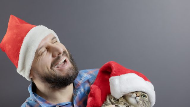 a man and cat in santa hats