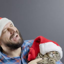a man and cat in santa hats