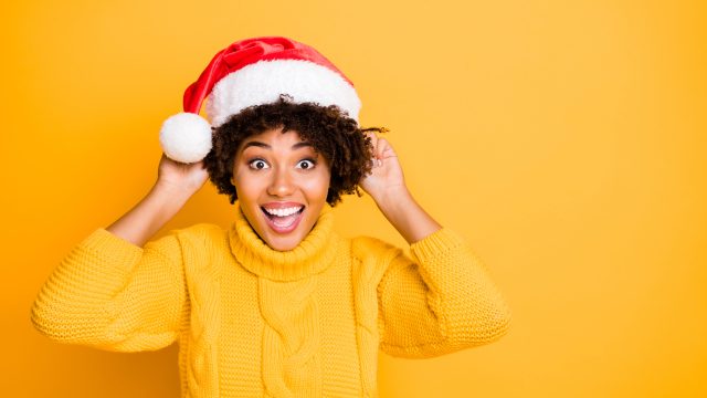woman in santa hat sharing laughing at christmas puns