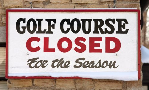 Sign at golf course in winter with snow. 