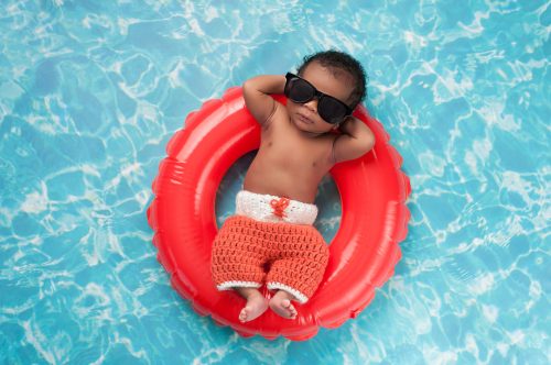 relaxed baby on a pool float in sunglasses