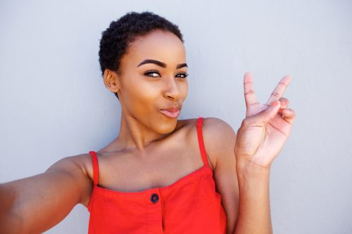 woman giving the peace sign to the camera