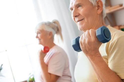Senior couple exercise together at home health care with dumbbells close-up