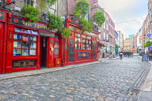 View down a cobblestone street in Dublin, Ireland showing the famed Temple Bar.