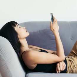 woman relaxing at home, browsing her smart phone.