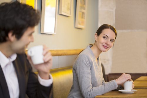 man flirting and making conversation with woman at a cafe