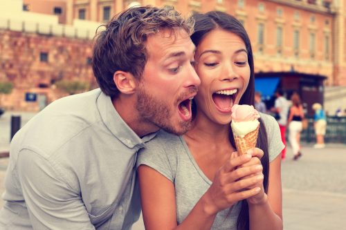 playful couple sharing an ice cream cone