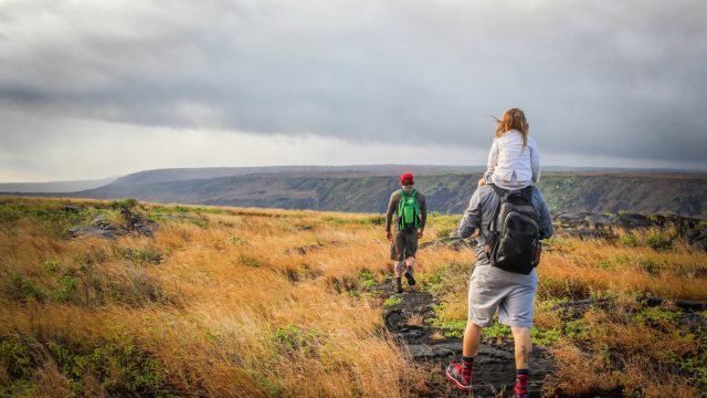 A family of three hiking in Hawaii Volcanoes National Park