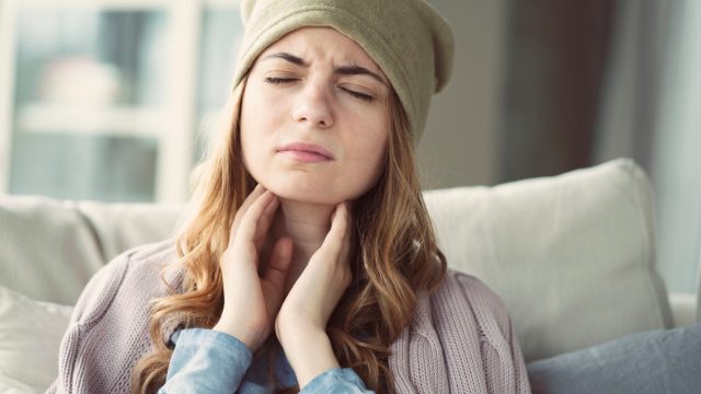 Woman suffering from a sore throat.