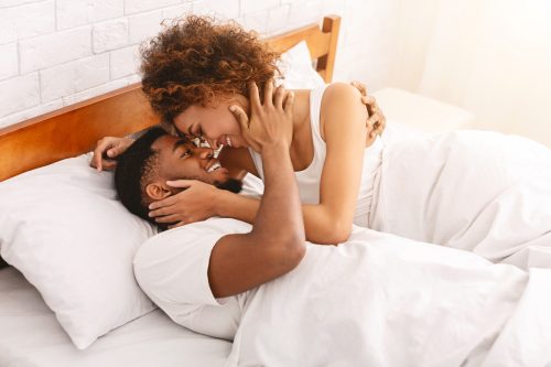 young black couple cuddling in bed