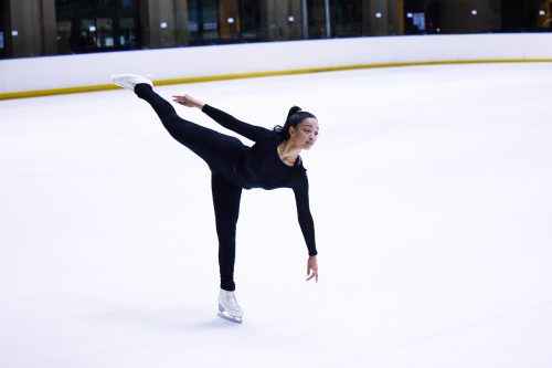 Shot of a young woman figure skating at a sports arena