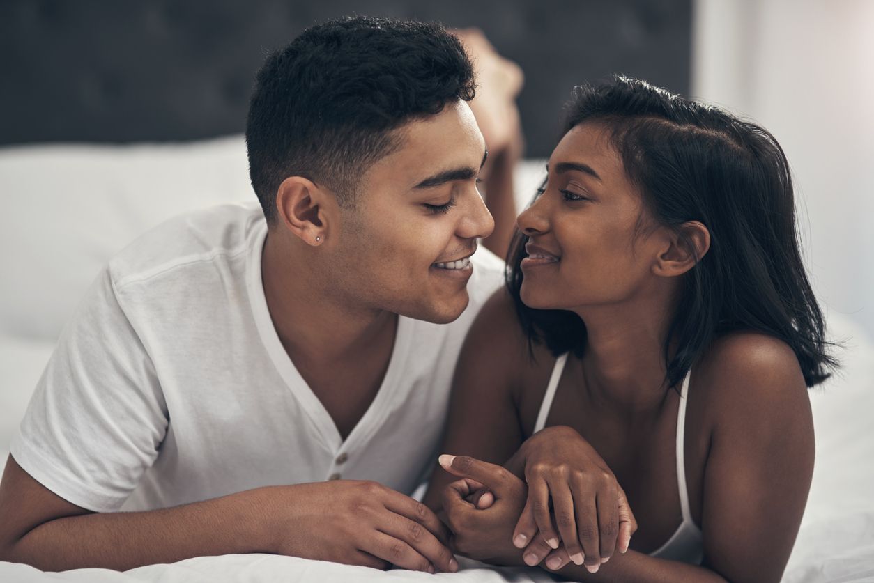 young couple kissing in bed