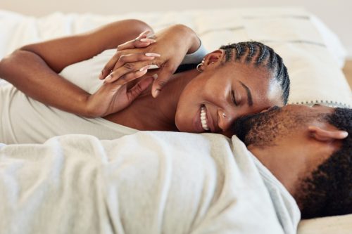 young black couple cuddling in bed