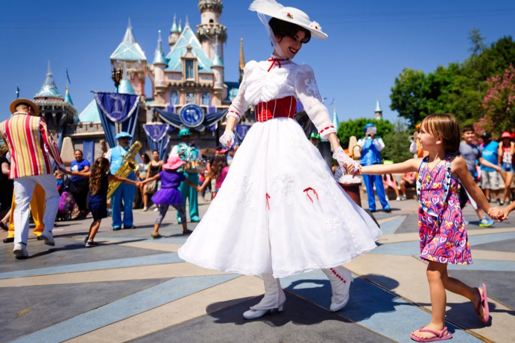 mary poppins holding little girl's hand at disneyland