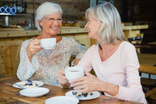 two older women having coffee together at a cafe