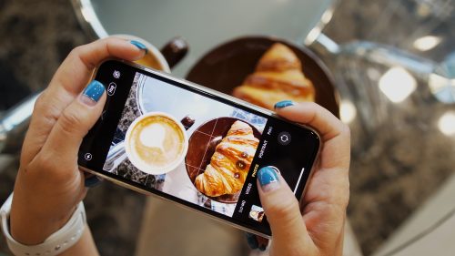 person taking a photo of food on their phone