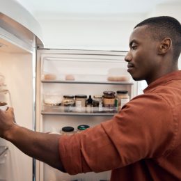A young man taking items out of his fridge