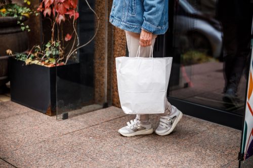 Woman in sneakers with shopping baq