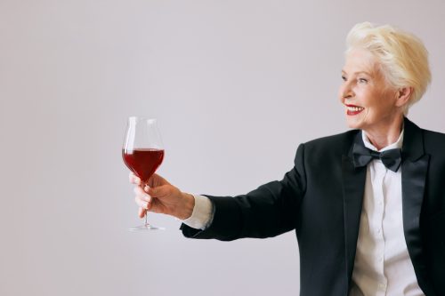 older woman in tuxedo and wine