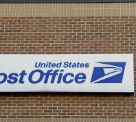 Exterior of United States Post Office with banner and logo.